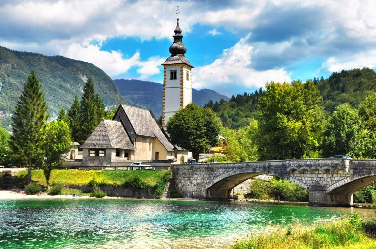 Bohinjer See, Kirche des Heiligen Johannes des Täufers mit Brücke. Triglav-Nationalpark, Julische Alpen, Slowenien.