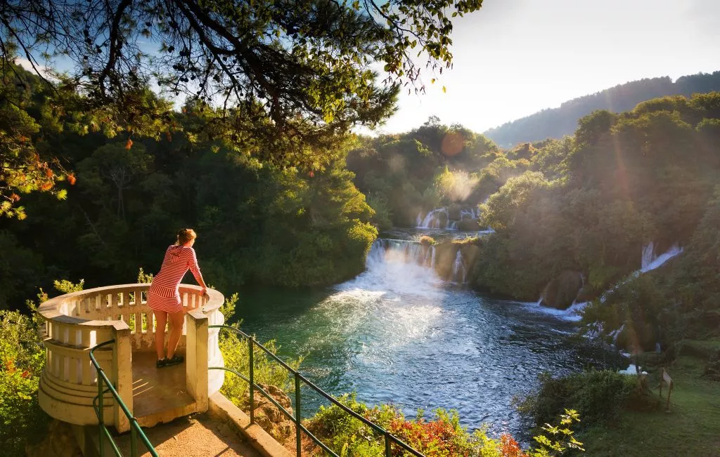 Young woman looks over the waterfalls of the Krka river in Krka national park in Croatia